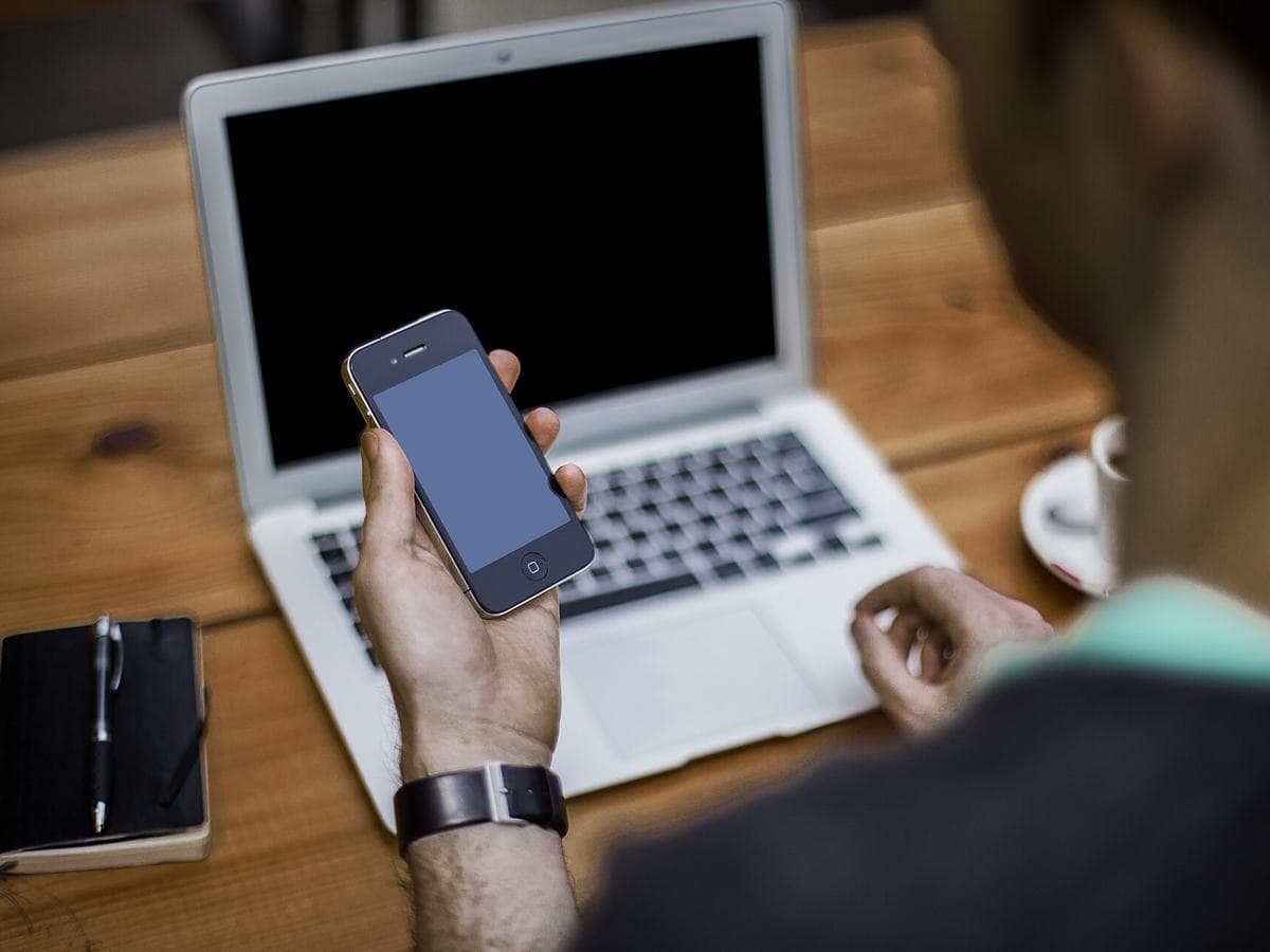 Photo via Wikimedia Commons (CC0) Checking a phone beside a laptop